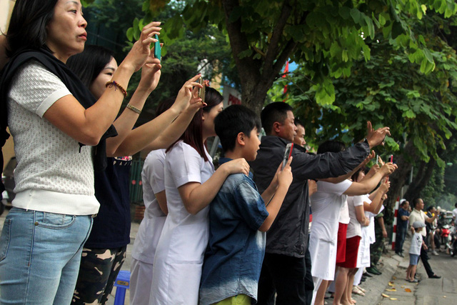 Trong l&uacute;c đo&agrave;n xe th&aacute;p t&ugrave;ng Tổng thống Mỹ tới Phủ chủ tịch, người d&acirc;n đ&atilde; tập trung dọc nhiều tuyến phố để đ&oacute;n v&agrave; chụp ảnh đo&agrave;n.&nbsp;