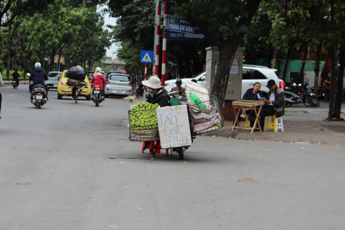 C&ocirc; b&aacute;n t&aacute;o rong tr&ecirc;n đường Ho&agrave;ng Quốc Việt đang co ro b&ecirc;n xe t&aacute;o.