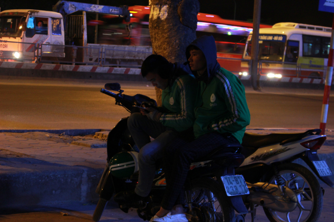 ...t&agrave;i xế xe &ocirc;m Grab đang co ro chờ kh&aacute;ch.