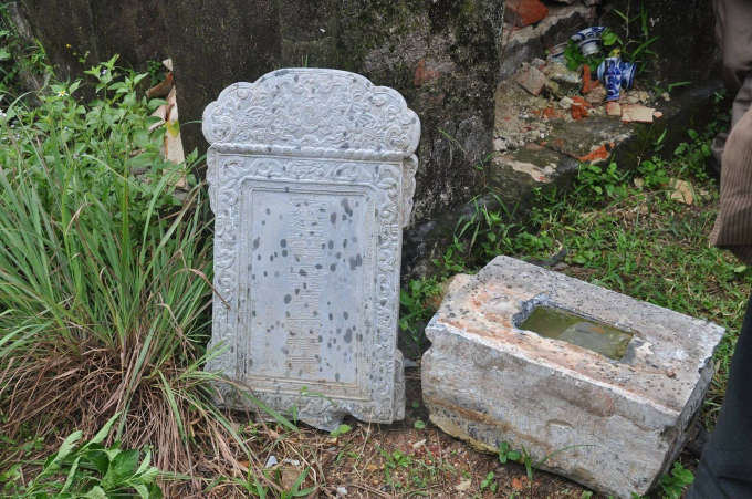 Bia mộ bị ph&aacute; hỏng v&agrave; đ&atilde; di chuyển ra ngo&agrave;i.