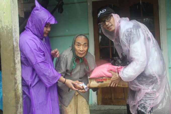 Ph&oacute;ng vi&ecirc;n Đăng Hậu (b&ecirc;n phải) trao qu&agrave; đến một b&agrave; cụ ở x&atilde; Quảng Phước, huyện Quảng Điền.