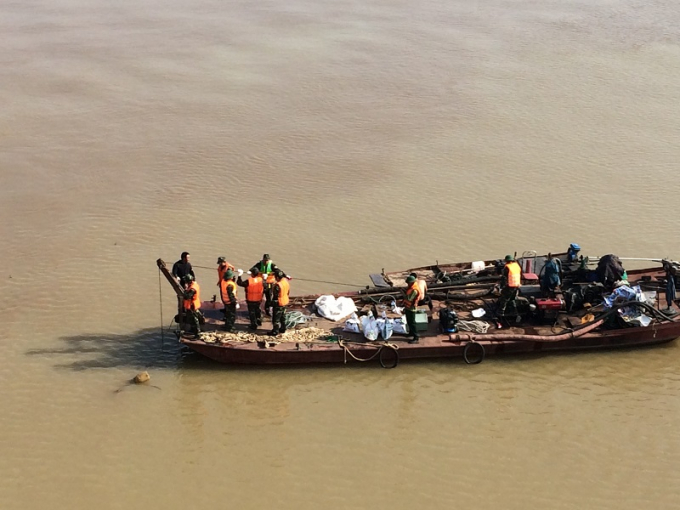 Quả bom được vớt l&ecirc;n mặt được dong theo thuyền để dắt v&agrave;o bờ (Ảnh: Một thế giới).