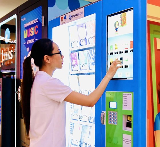 Một bạn đọc&nbsp; mua s&aacute;ch tại m&aacute;y b&aacute;n s&aacute;ch tự động