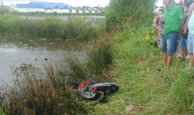 Chiếc xe m&aacute;y hư hỏng nằm dưới bờ vu&ocirc;ng t&ocirc;m.
