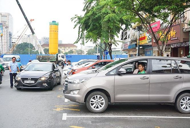 Nh&acirc;n vi&ecirc;n đ&ocirc; thị hướng dẫn t&agrave;i xế cho xe v&agrave;o b&atilde;i đỗ c&oacute; thu ph&iacute;