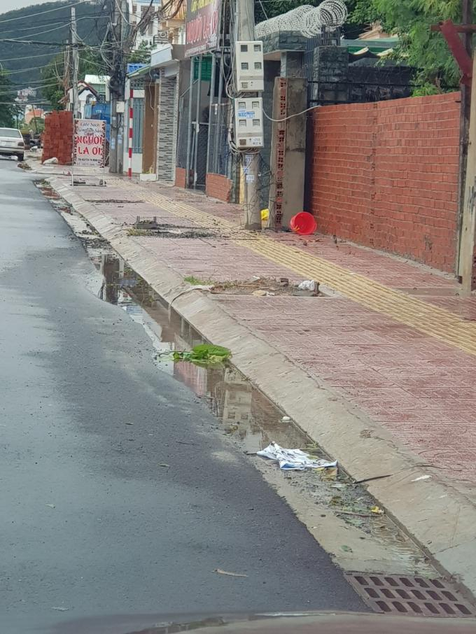 Nước đọng dọc theo khu vực đường đ&atilde; thi c&ocirc;ng xong lớp mặt. Kh&ocirc;ng chỉ vậy, miệng hố ga cao khiến nước mưa kh&ocirc;ng thể chảy v&agrave;o hố được.