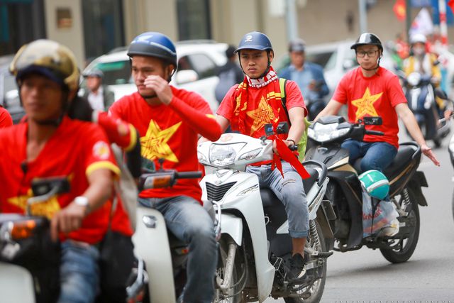 Nhóm cổ động viên đi theo hàng lối, và đội mũ bảo hiểm đầy đủ đảm bao an toàn khi tham gia giao thông.