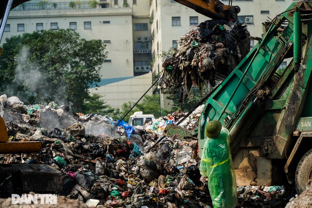 C&ocirc;ng nh&acirc;n vệ sinh thuộc C&ocirc;ng ty m&ocirc;i trường đ&ocirc; thị Vĩnh Y&ecirc;n đang tiến h&agrave;nh dọn r&aacute;c ra khỏi b&atilde;i tập kết r&aacute;c tạm thời tr&ecirc;n phố Phạm Văn Bạch.