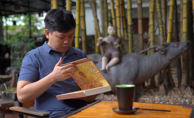 Nghệ nhân thủy ấn Đồng Phước Quang nâng niu tác phẩm bìa lụa rất cầu kỳ, tinh tế của mình.