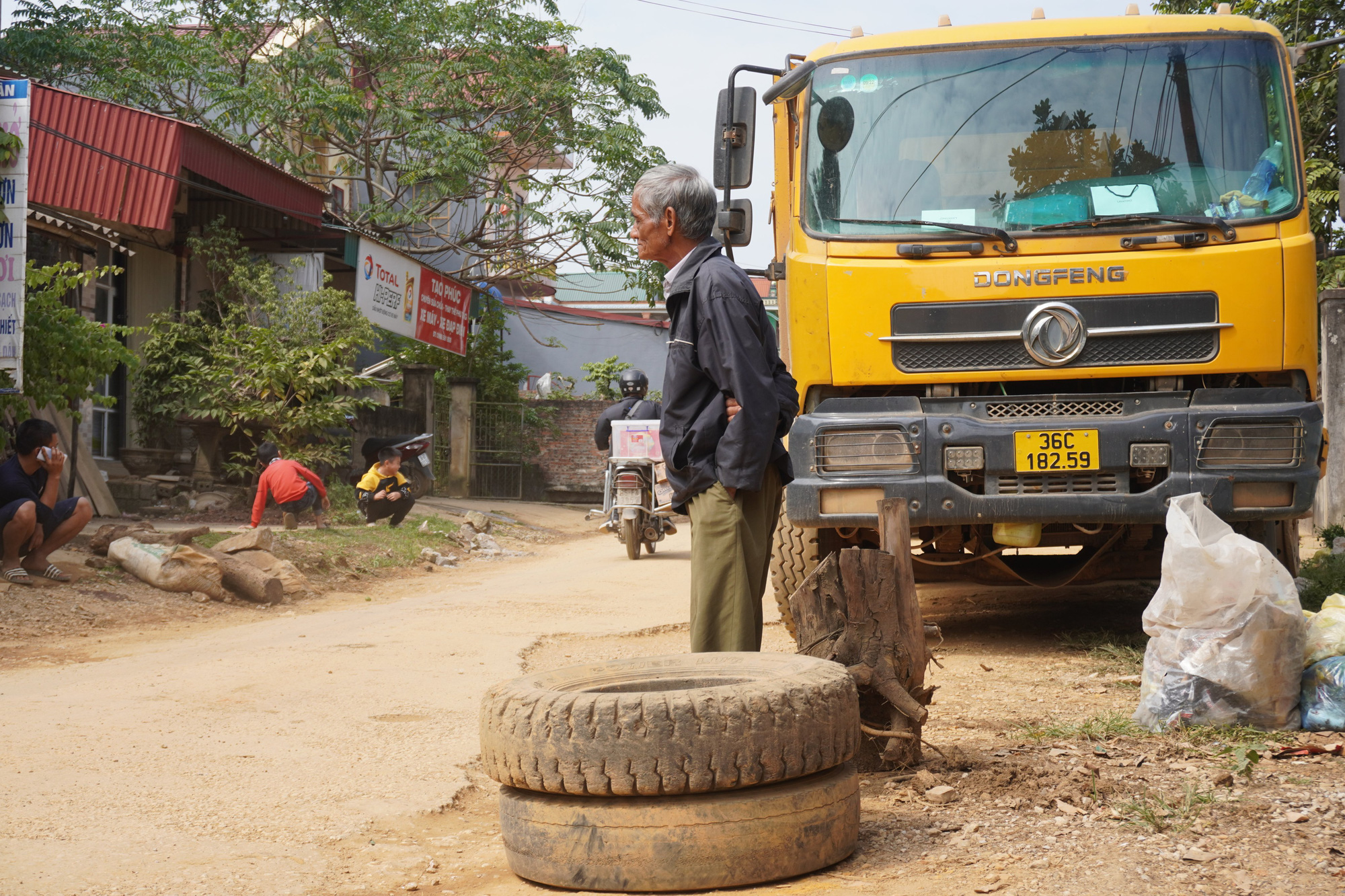Dân mang thùng phuy, khúc gỗ... chặn đoàn xe tải chở đất - Ảnh 3.