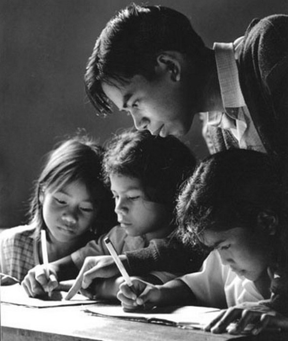 Hình ảnh thầy cầm tay dạy trò viết từng nét chữ. 