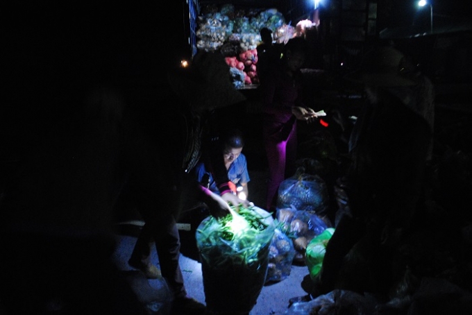 Mọi mua b&aacute;n, trao đổi rau, củ tại chợ đ&ecirc;m Quỳnh Văn chủ yếu d&ugrave;ng bằng đ&egrave;n pin. Ảnh Duy Ngợi