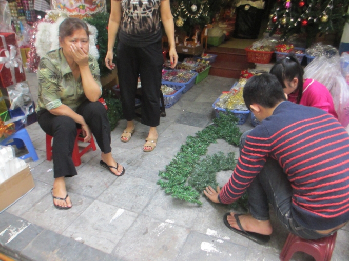 Người đ&agrave;n &ocirc;ng c&ugrave;ng mọi người đang l&agrave;m c&acirc;y th&ocirc;ng Noen chuẩn bị cho m&ugrave;a lễ Gi&aacute;ng sinh sắp tới