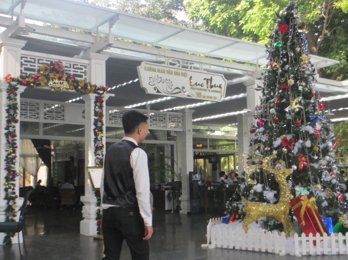 Một nh&agrave; h&agrave;ng tr&ecirc;n Hồ Gươm cũng đ&atilde; trang tr&iacute; c&acirc;y th&ocirc;ng Noen trước cửa