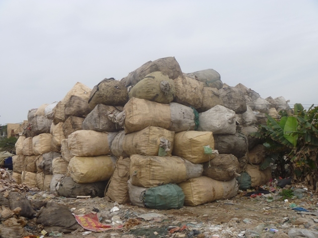 Một khối lượng lơn bao tải rác được chất thành núi