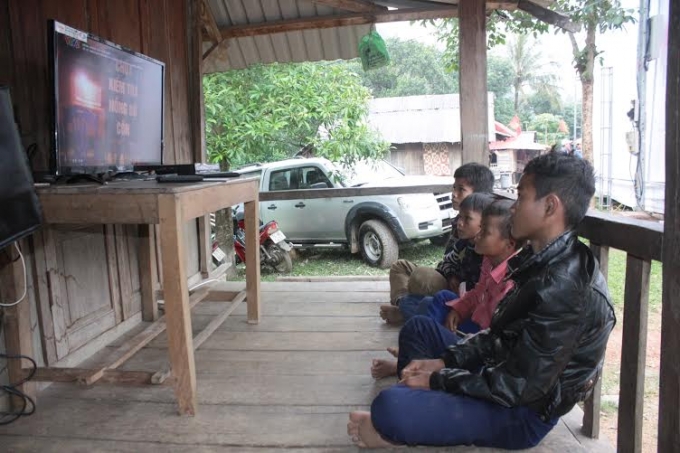 Trẻ em th&ocirc;n Cu Pua vui vẻ b&ecirc;n chiếc tivi.