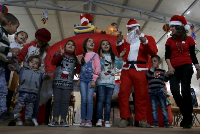 Trẻ em Iraq h&aacute;t những b&agrave;i h&aacute;t Gi&aacute;ng sinh c&ugrave;ng &ocirc;ng gi&agrave; Noel tại một khu trại gần Baghdad.  (Ảnh: Reuters)