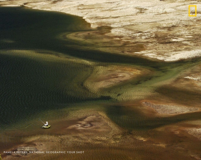 Một người đ&agrave;n &ocirc;ng đang c&acirc;u c&aacute; tr&ecirc;n một hồ cạn do hạn h&aacute;n ở gần d&atilde;y n&uacute;i&nbsp;Sierra Nevada, California.