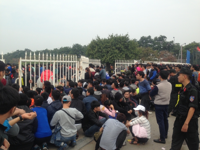 Người mua v&eacute; đứng chờ l&acirc;u tranh thủ ngồi nghỉ ch&acirc;n ngay tại chỗ