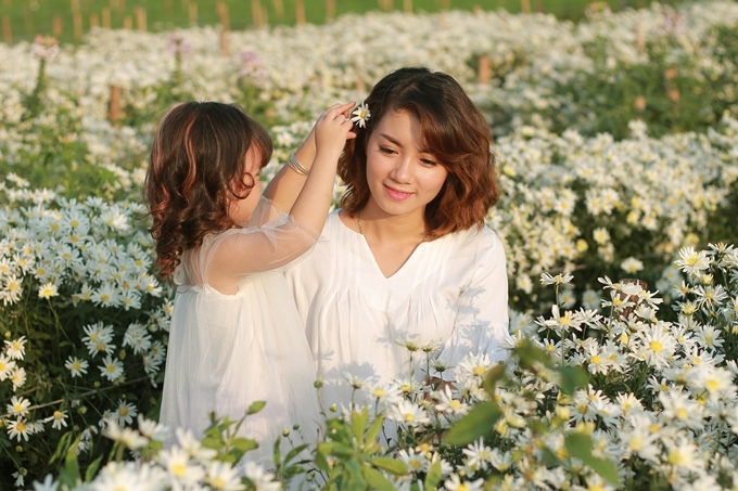 Phương Nhi h&aacute;i một b&ocirc;ng hoa c&aacute;i l&ecirc;n m&aacute;i t&oacute;c mẹ như để thể hiện l&ograve;ng biết ơn đến c&aacute;c đấng sinh th&agrave;nh.