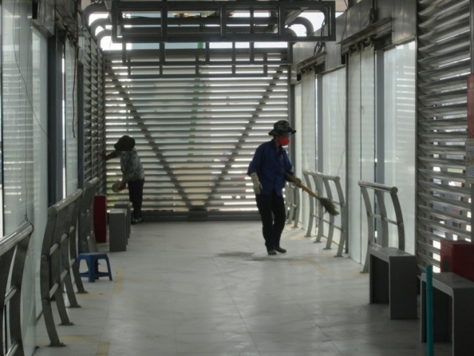 C&ocirc;ng nh&acirc;n đang lau ch&ugrave;i bụi bẩn ở c&aacute;c nh&agrave; chờ xe bu&yacute;t nhanh.