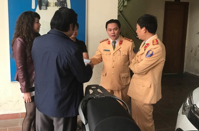 Đại diện đội CSGT số 2 b&agrave;n giao chiếc xe m&aacute;y SH cho chị Hoa.