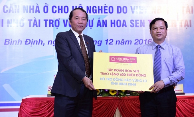 &nbsp;&Ocirc;ng Trần Ngọc Chu - Ph&oacute; Chủ tịch HĐQT, Tổng gi&aacute;m đốc Tập đo&agrave;n Hoa Sen trao bảng tượng trưng ủng hộ lũ lụt đồng b&agrave;o tỉnh B&igrave;nh Định cho &ocirc;ng Nguyễn Tuấn Thanh - PCT UBND Tỉnh.