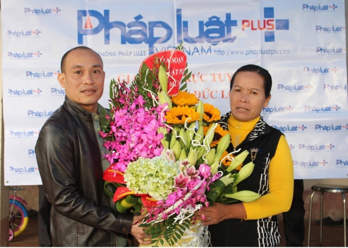 B&agrave; Nguyễn Thị Mai vợ &ocirc;ng H&agrave;n Đức Long rất x&uacute;c động khi nhận hoa ch&uacute;c mừng từ đại diện T&ograve;a soạn Ph&aacute;p luật Plus.