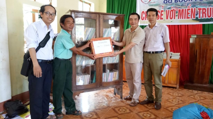 Thầy Ch&acirc;u (ngo&agrave;i c&ugrave;ng b&ecirc;n tr&aacute;i) đ&oacute;n nhận nhiều đầu s&aacute;ch từ c&aacute;c nh&agrave; hảo t&acirc;m.