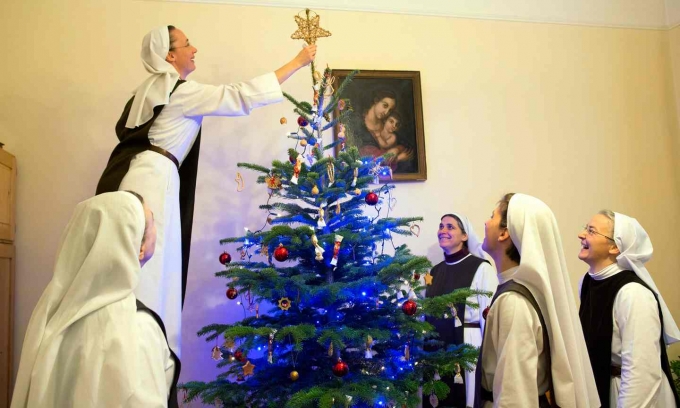 C&aacute;c nữ tu C&ocirc;ng gi&aacute;o đang trang tr&iacute; c&acirc;y th&ocirc;ng Noel tại nh&agrave; thờ Perpetual Adoration ở th&agrave;nh phố Budapest, Hungary. (Ảnh: Bea Kallos / EPA)