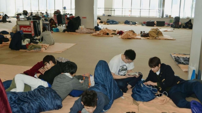 Những h&agrave;nh kh&aacute;ch bị mắc kẹt tại s&acirc;n bay New Chitose ở th&agrave;nh phố Sapporo. (Ảnh: Kyodo)