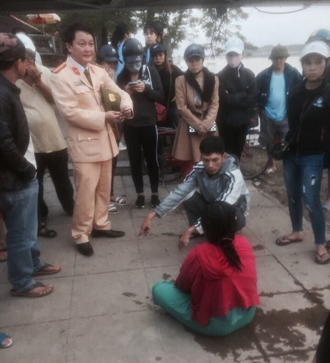 Chị D (người ngồi, &aacute;o đỏ) được CSGT C&ocirc;ng an TP.Huế cứu sống sau khi nhảy cầu. (Ảnh: FB)