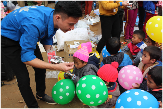 C&aacute;c bạn sinh vi&ecirc;n ph&aacute;t kẹo cho c&aacute;c em hoc sinh.