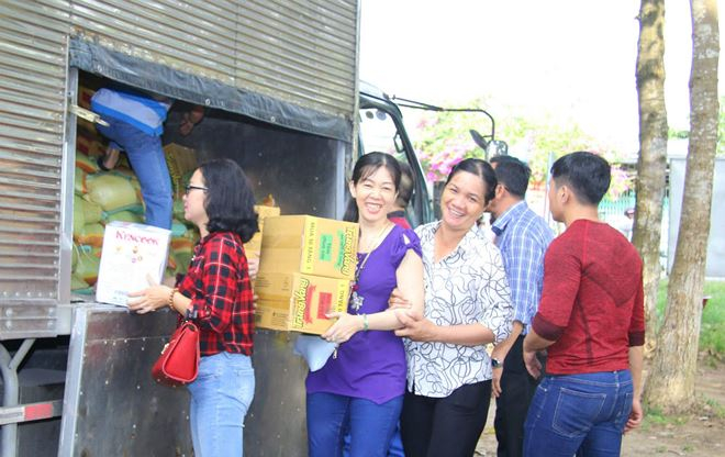 Mọi người c&ugrave;ng nhau vận chuyển gạo v&agrave; c&aacute;c nhu yếu phẩm v&agrave;o trao cho b&agrave; con ngh&egrave;o. Ảnh Thành Th&acirc;̣t.