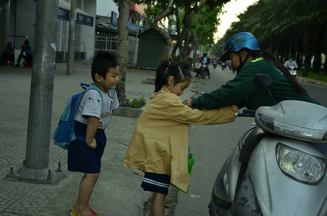Tr&ecirc;n đường đến trường, phụ huynh phải dừng xe lại để mặc th&ecirc;m &aacute;o ấm cho trẻ