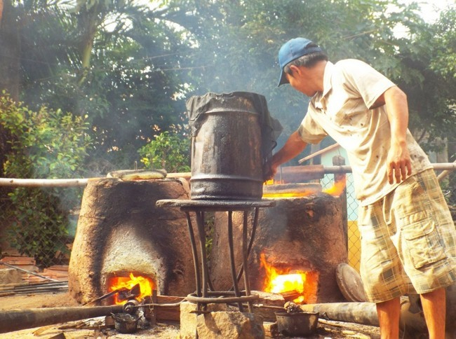 Người d&acirc;n đang chăm ch&uacute;t cho nồi l&ograve; được ra sản phẩm đẹp mắt.