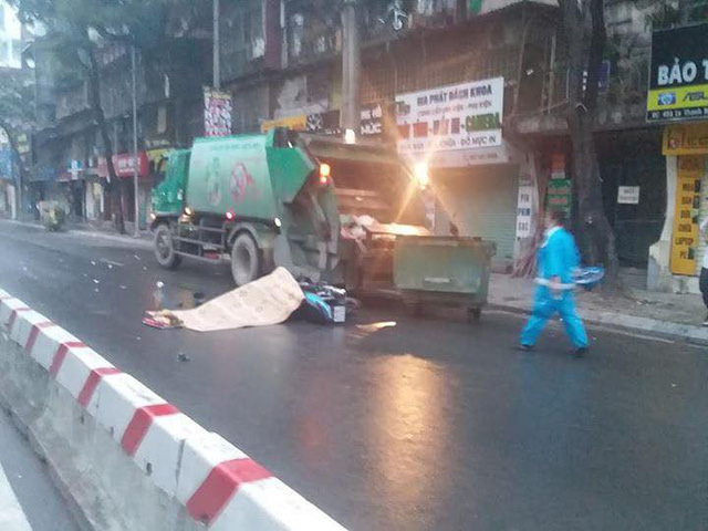 Chiếc xe chở r&aacute;c đỗ b&ecirc;n đường trong đ&ecirc;m mưa. (Ảnh: L&ecirc; Phương).