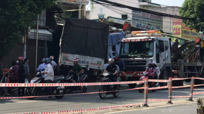 Sau khi nổ lốp chiếc xe tải t&ocirc;ng h&agrave;ng loạt dải ph&acirc;n c&aacute;ch rồi t&ocirc;ng thẳng v&agrave;o 2 nh&agrave; d&acirc;n