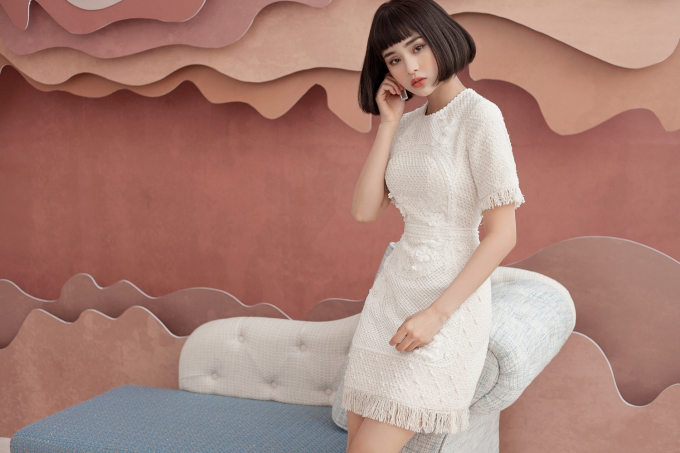 Ca sỉ HIền Hồ chọn chiếc đầm cocktail m&agrave;u trắng tinh kh&ocirc;i bằng chết liệu vải tweed. Đ&acirc;y l&agrave; loại vải c&oacute; bề mặt sần, chống ẩm ướt v&agrave; giữ ấm tốt, do đ&oacute; th&iacute;ch hợp với những ng&agrave;y chuyển m&ugrave;a cuối năm.