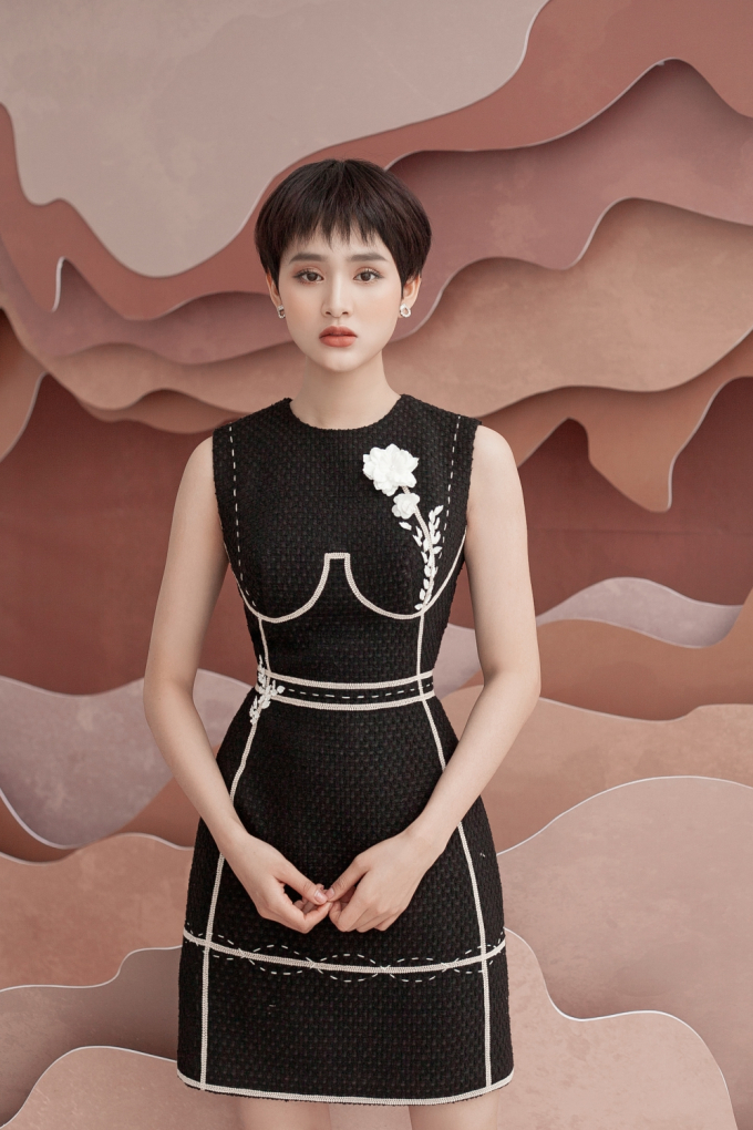 Chủ nh&acirc;n hit Rồi người thương cũng h&oacute;a người dưng diện một thiết kế m&agrave;u đen sang trọng. Nh&agrave; thiết kế tạo hiệu ứng nổi bật bằng những đường đăng ten v&agrave; đột chỉ. B&ocirc;ng hoa ren th&ecirc;u sắc sảo tr&ecirc;n nền vải tweed tăng độ ngọt ng&agrave;o cho trang phục.