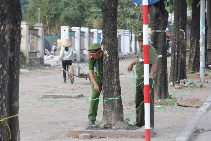 Lực lượng an ninh thao dỡ những r&agrave;o cản tr&ecirc;n vỉa h&egrave; tuyến đường ch&iacute;nh lưu th&ocirc;ng qua s&acirc;n vận động.