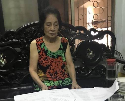 B&agrave; Đặng Thị G&aacute;i mệt mỏi b&ecirc;n đống hồ sơ giấy tờ li&ecirc;n quan đến việc cấp sổ đỏ nh&agrave; m&igrave;nh.