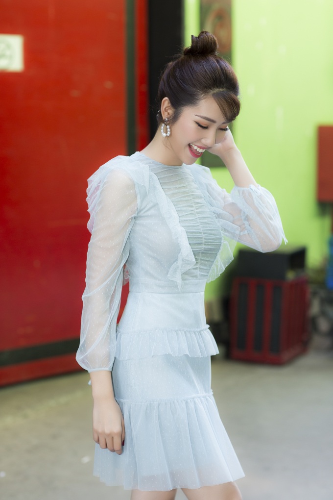 Th&uacute;y Ng&acirc;n chọn v&aacute;y xếp tầng chất liệu voan lưới c&oacute; t&ocirc;ng xanh nhẹ nh&agrave;ng. Người đẹp kết&nbsp;hợp th&ecirc;m phụ kiện l&agrave; hoa tai ngọc trai v&agrave; gi&agrave;y cao g&oacute;t &aacute;nh bạc.