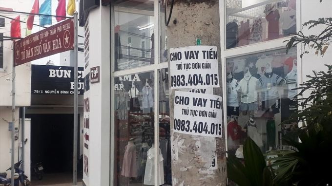 Tờ rơi quảng c&aacute;o cho vay tiền d&aacute;n ngay cạnh khu phố văn h&oacute;a. Ảnh Đ&igrave;nh Văn