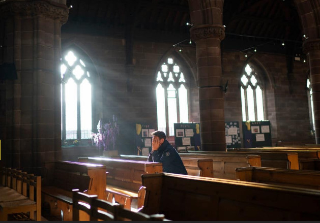 Một người đ&agrave;n &ocirc;ng cầu nguyện trong nh&agrave; thờ trong đ&ecirc;m Gi&aacute;ng sinh ở Birmingham, Anh, ng&agrave;y 24/12. Ảnh: Getty.