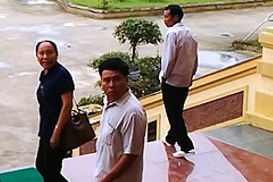 &Ocirc;ng Ng&ocirc; Tr&iacute; Ca (giữa) khi rời trụ sở TAND tỉnh&nbsp;Nghệ An&nbsp;ng&agrave;y 19-10 sau khi c&oacute; h&agrave;nh vi g&acirc;y rối tại phi&ecirc;n t&ograve;a - Ảnh: B&aacute;o Nghệ An