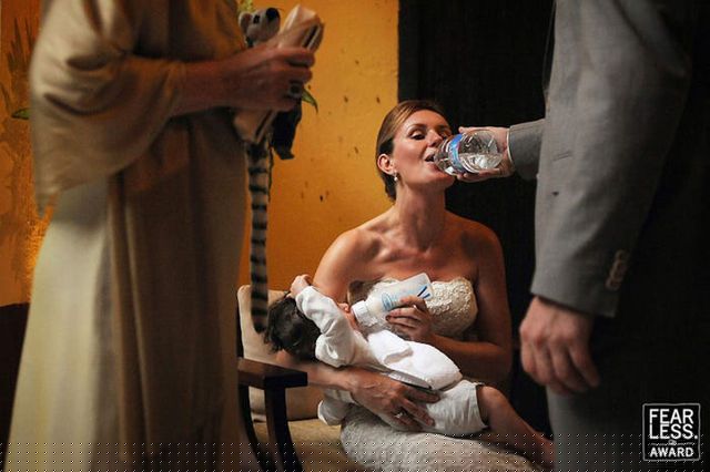 Cô dâu trong bức ảnh đang vừa mỉm cười vừa uống nước trong khi cho con bú bình sữa. Bức ảnh tuyệt đẹp này là tác phẩm của Daniel Aguilar gửi dự thi trong giải thưởng Fearless năm 2011.