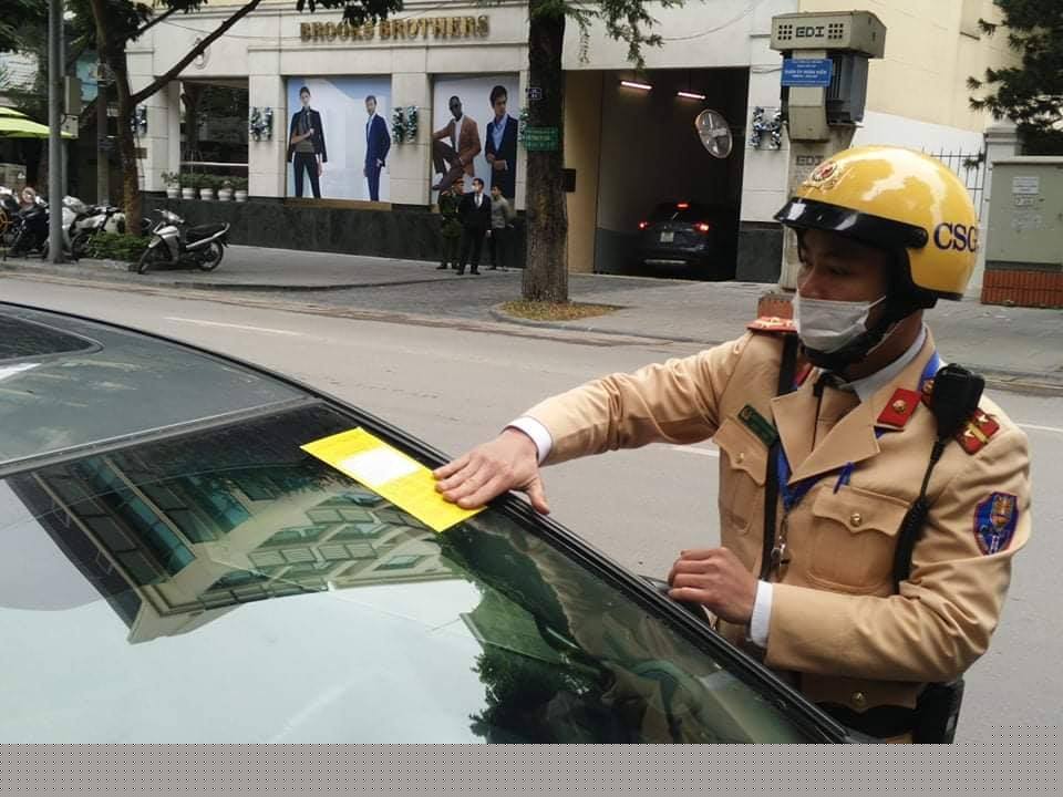 Chiến sĩ CSGT dán mẫu “phạt nguội” đối với xe vi phạm.
