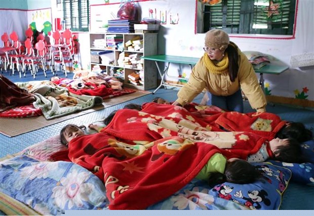 Giáo viên luôn chăm sóc cho giấc ngủ của học sinh đặc biệt trong những ngày nhiệt độ xuống thấp. (Ảnh: Quý Trung/TTXVN)