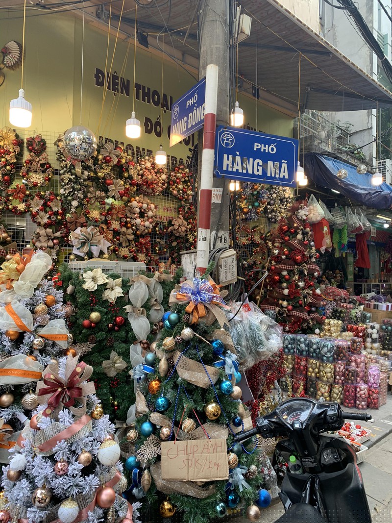 Những chùm chuông và cây thông Noel với nhiều màu sắc và kích cỡ khác nhau cũng được bày bán dọc phố Hàng Mã để thu hút khách hàng.